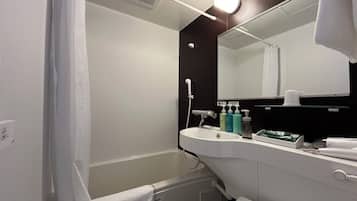 A modern bathroom with a white sink, mirror, and shower. There are toiletries on the sink and a towel hanging on the wall.