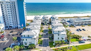 A coastal hotel with multiple-story buildings, a parking lot, and a beach view. - Pelican Bluff, a premier beachside home. Private pool and elevator by Kaiser Vacations (Orange Beach)