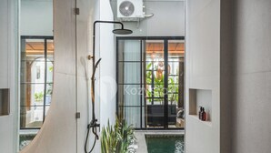 A modern bathroom with a glass shower enclosure, a small pool, and a view of the outdoors. - Lucenta Villa by Kozystay - Canggu (Canggu)