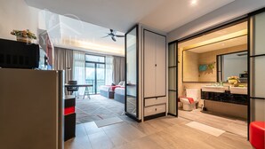 A modern hotel room with a kitchenette, a balcony, a large window, and a bathroom with a sink and toilet. - Maison 101 Residence walk to Menara KL (Kuala Lumpur)