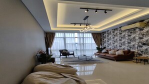 Een moderne woonkamer met een bank, salontafel en een grote ploonzak.