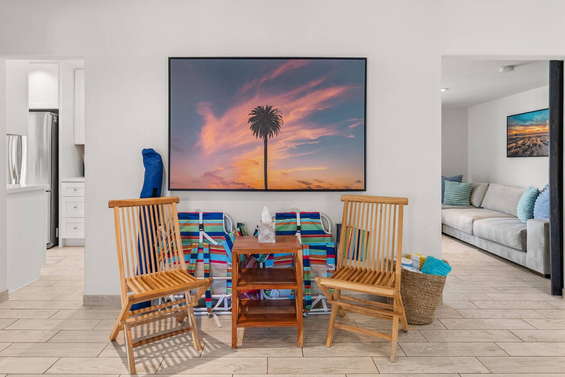 A dining area with a wooden table, two chairs, and a colorful striped bag.