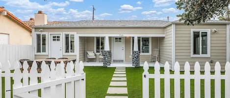 A single-story house with a front porch, a mailbox, and a number 719 on the front.