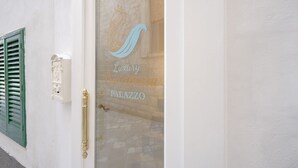 A building entrance with a glass door featuring a logo and text reading "Luxury Principessa Palazzo". - Ducale – Historic Charm and Comfort in the Heart of Monopoli (Monopoli)