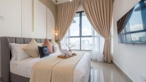 Un dormitorio moderno con una cama grande, vistas a la ciudad y un televisor en la pared.
