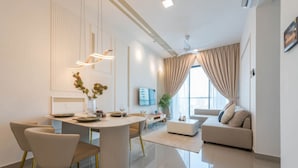 Una sala de estar moderna con comedor, un sofá y un televisor.