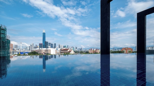 Una piscina con el horizonte urbano al fondo.