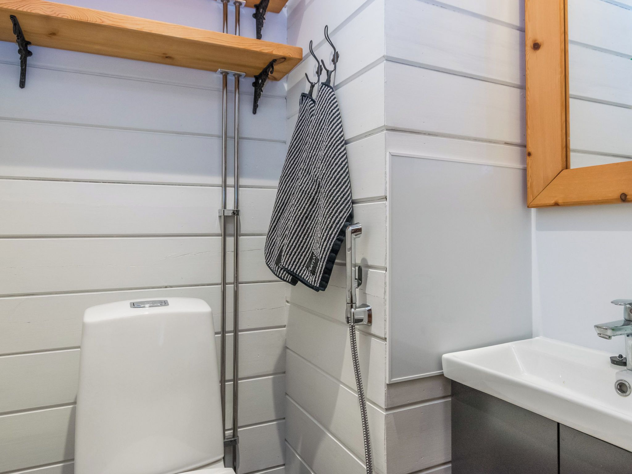 A bathroom with a white toilet, a shower, and a sink.