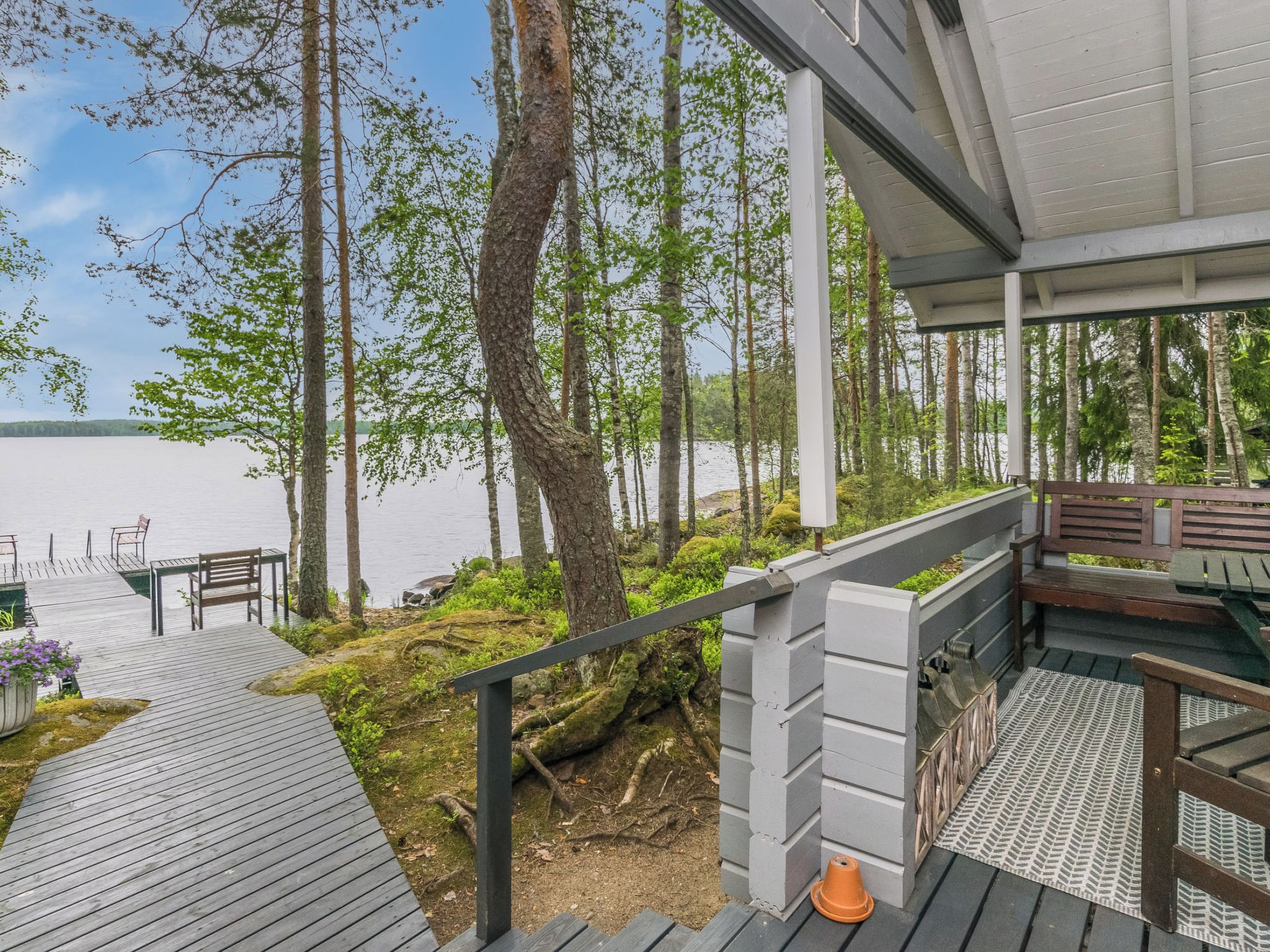 A wooden deck with a view of a lake and forest.