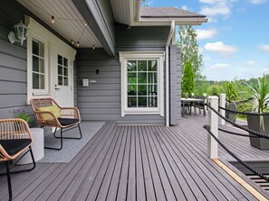 A wooden deck with outdoor furniture, a mailbox, and a view of the surrounding greenery. - Aurinkoranta by Interhome (Ikaalinen)