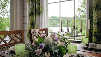 A dining table set with plates, glasses, and a floral centerpiece.