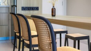 A modern dining area with a long table, four chairs, and a vase with flowers on the table. - Residensi Majestic Maxim Condo (Kuala Lumpur)