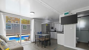 A modern living room with a sofa, a dining table, and a kitchen area. - Monkey Houses – 400m From Beach – Peace, Comfort & Nature on the Pacific Coast (Sardinal)