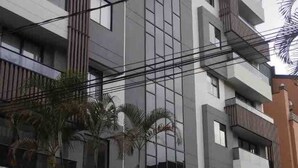 Un immeuble à plusieurs étages doté d’une architecture moderne, avec des balcons et de grandes fenêtres.
