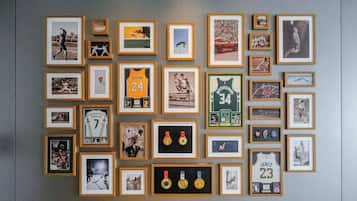 Una pared con varios recuerdos deportivos enmarcados, incluyendo camisetas y medallas.