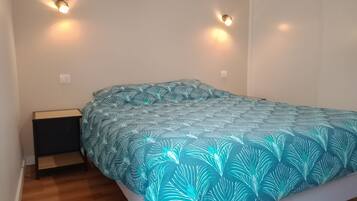 Ein Schlafzimmer mit einem Bett, zwei Wandlampen, einem Nachttisch und Holzboden.