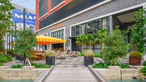 A modern building with a sign reading "CASA GIANNNA" and outdoor seating with umbrellas. - Chic 2/2 Condo with City views (Miami)