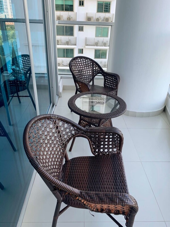 A balcony with wicker furniture, including two chairs and a small round table. - Blue Home I Spacious 1 Bed With Park View Parkside (Panama City)