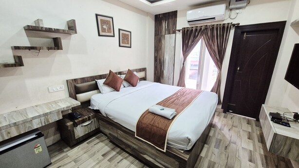 Une chambre d’hôtel comprenant un lit, des tables de chevet, une armoire, un appareil de climatisation et un téléviseur.