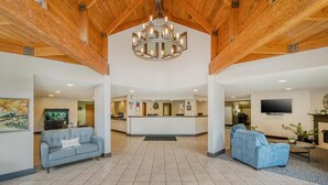 A spacious lobby with a reception desk, two sofas, a chandelier, and a television. - Surestay Plus Hotel By Best Western Elizabethtown Hershey (Elizabethtown)