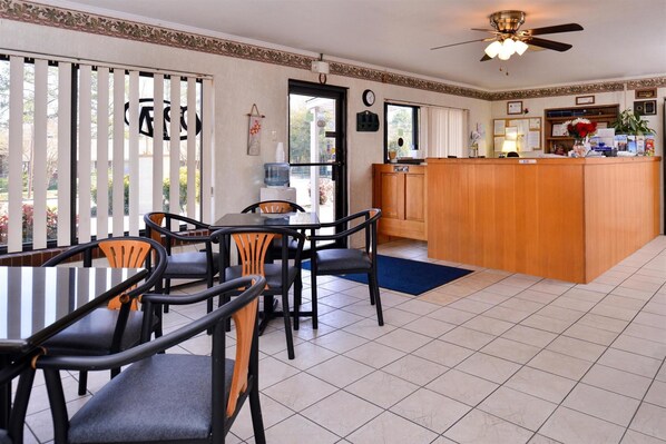 A hotel room with a dining area, a kitchen, and a reception desk. - Loyalty Inn Rockingham (Rockingham)