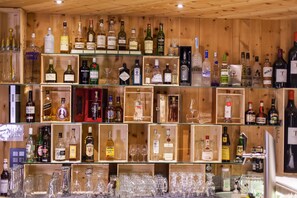 A liquor store with shelves of various bottles and glasses. - TOP Hotel San Gian St. Moritz (St. Moritz)