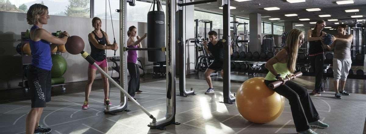 Ein Fitnessstudio mit Trainingsgeräten, einem Boxsack und trainierenden Personen.