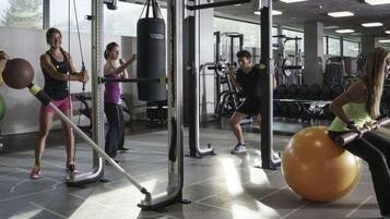 Ein Fitnessstudio mit Trainingsgeräten, einem Boxsack und trainierenden Personen.