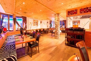 Ein Restaurant mit Holzbalkendecken, Sitzgelegenheiten in Zebra-Muster und einer Steinsäule.