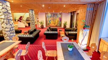 Eine Hotelhalle mit rotem Teppich, Holzmöbeln, einer Treppe und einem großen Gemälde.