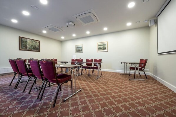 A conference room with a large table and multiple chairs, a carpeted floor, and ceiling lights. - Ratonda Centrum Hotel (Vilnius)