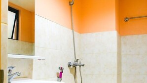 A bathroom with a white sink, a toilet, and a shower. - OYO 499 Le Pensione De San Jose (Tagbilaran)