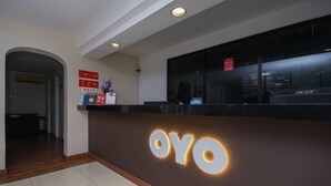 Egy recepciós pult, a falra kiírt, világító „OYO” felirattal.