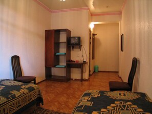 A room with two beds, a desk with a television, and a wardrobe. - Rohat Mirobad (Tashkent)