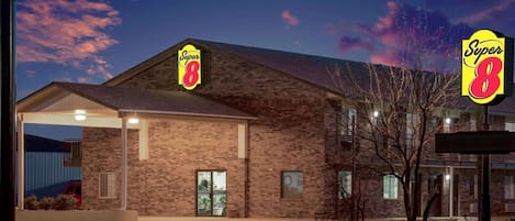 A Super 8 hotel with a brick facade, large windows, and a covered parking area.