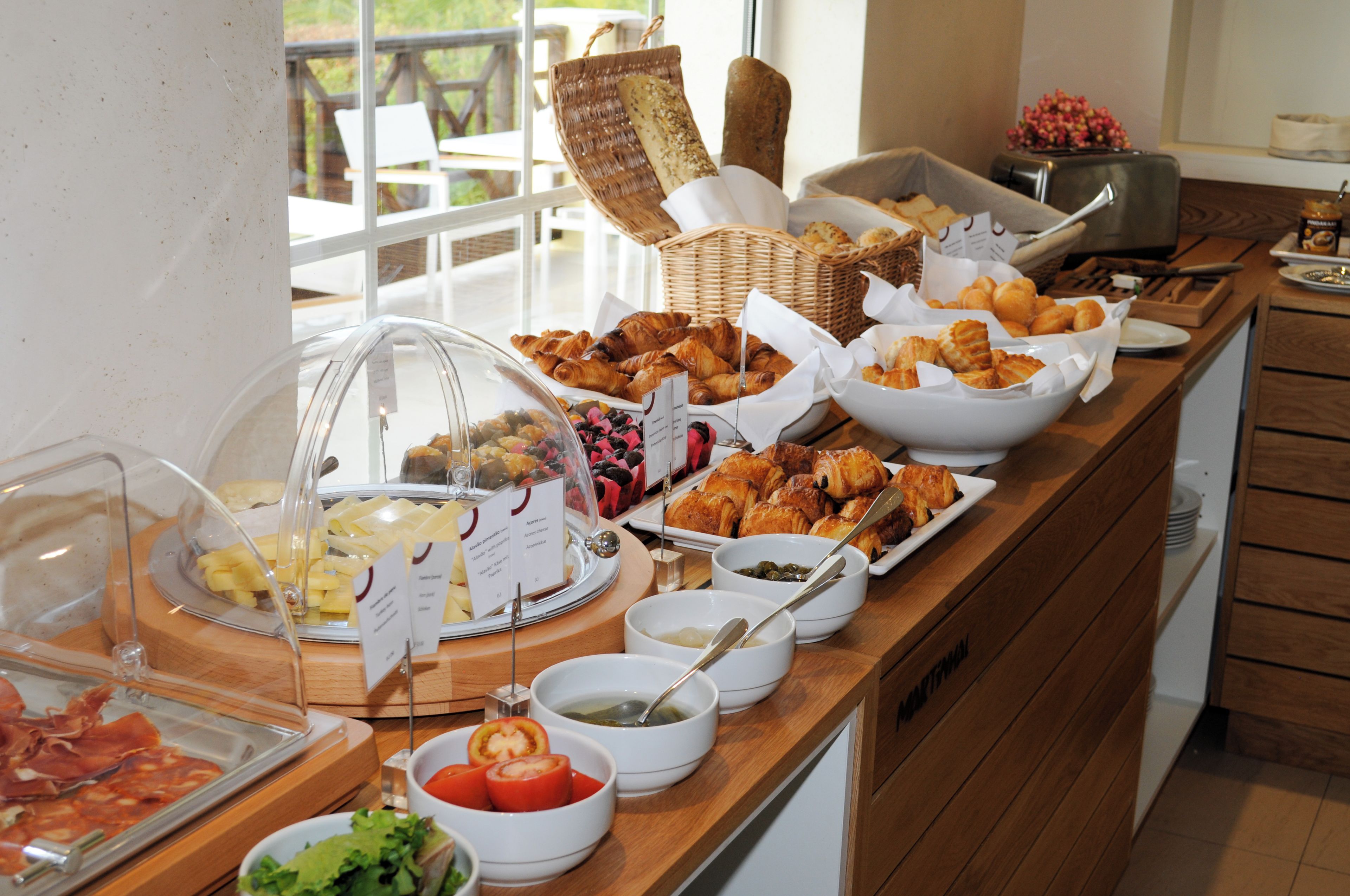 A buffet with various food items, including pastries, meats, and salads.