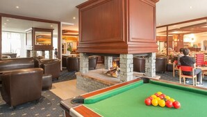 A pool table with balls, a fireplace, and leather seating. - Residence Les Bergers (Huez)
