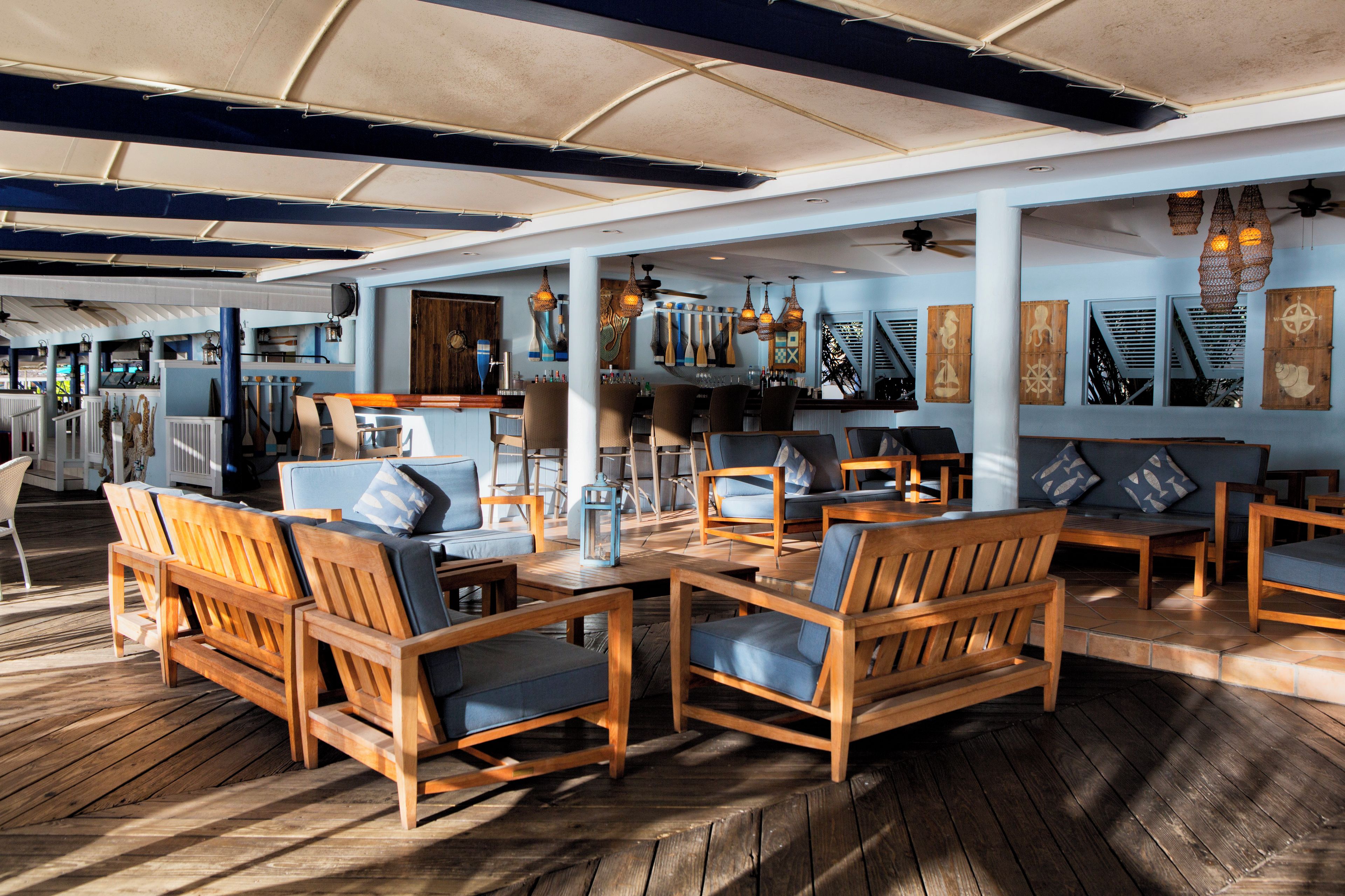A spacious indoor area with wooden furniture, a bar area, and decorative wall elements.