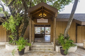 A wooden reception building with a sign reading 'TRANQUILITY' and a view of the interior. - St. Jamess Club Resort & Villas (Mamora Bay)