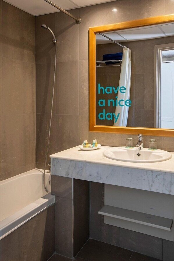 Une salle de bain moderne avec une douche, un lavabo et un miroir.