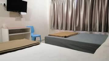 A hotel room with a bed, a desk, a chair, and a TV mounted on the wall.