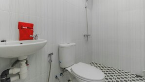 Un baño con lavamanos, inodoro y ducha blancos.