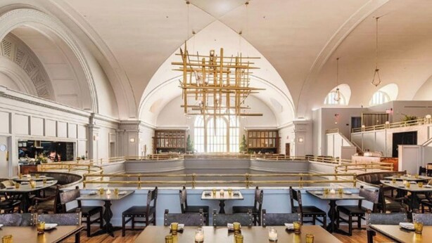 A spacious interior with high ceilings, a central open area, and seating arranged around it. - The Line DC (Washington)