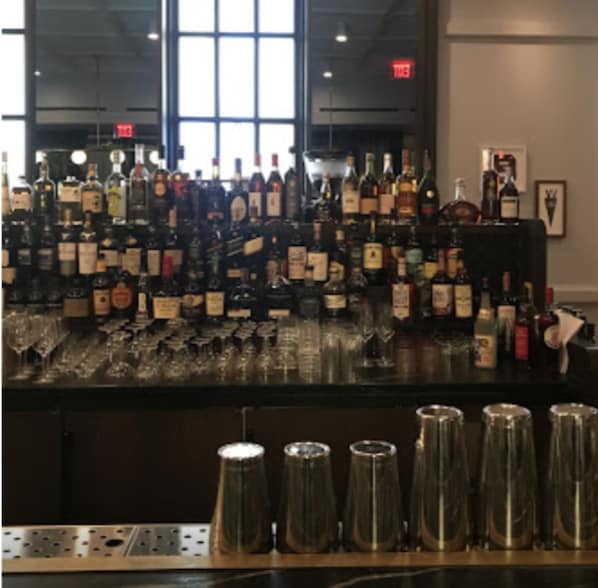 Una zona de bar con una variedad de botellas de licor y vasos.