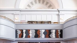 A lobby with a reception desk, seating area, and a high ceiling with decorative moldings. - The Line DC (Washington)