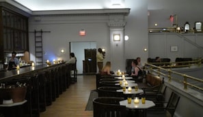 A restaurant interior with multiple tables, bar area, and a staircase. - The Line DC (Washington)