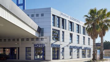 Ein modernes Hotel mit einem gut sichtbaren 'Hotel Logroño'-Schild, mehreren Eingängen und einem Restaurant.