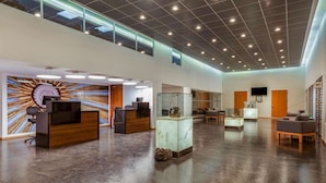 A spacious lobby with a reception desk, seating area, and display cases. - La Quinta by Wyndham San Jose Chiapa Puebla (San Jose Chiapa)