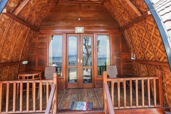 Una cabana de fusta amb un balcó, una porta amb un rètol i vistes al paisatge.