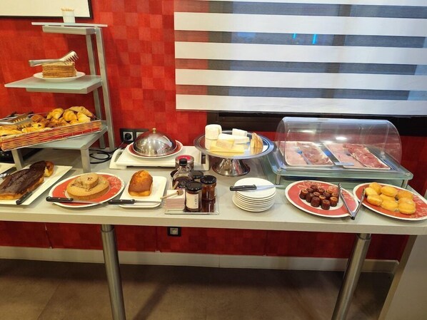 A buffet with various food items including pastries, meats, and condiments. - Grand Hotel de Sarlat (Sarlat-la-Canéda)